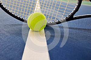 Tennis ball and racquet on a court line