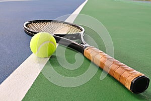 Tennis ball and racquet on a court line