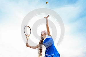 Tennis ball serving. Correct stance and practiced movements are essential for a good shot. A talented tennis player woman has been