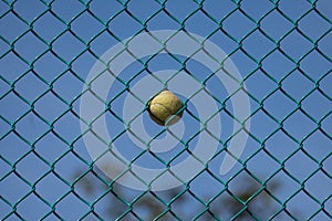 Tennis ball stuck in a wired fence