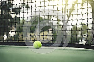 Tennis ball on tennis court with net in background