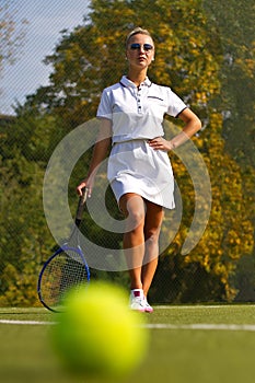 Tennis ball on the tennis court with the player in the background