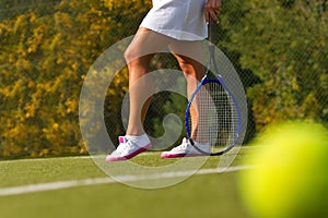 Tennis ball on the tennis court with the player in the background