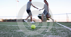 Tennis ball and tennis players shaking hands in background