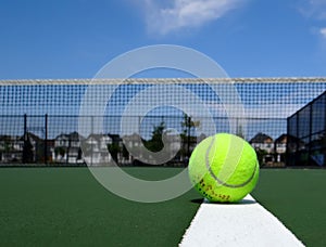 Tennis ball on the white line of the green tennis court