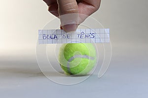 Tennis ball word written on a piece of paper, Bola de Tenis in Spanish language