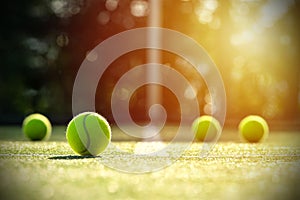 Tennis balls on grass court with sunlight