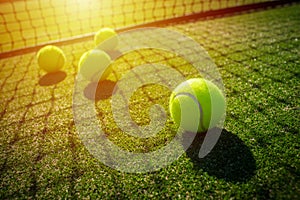 Tennis balls on grass court with sunlight