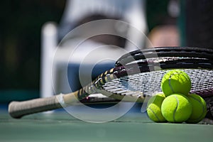 Tennis balls and racket on court