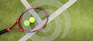 Tennis balls and racket on synthetic grass court background. top view with copy space