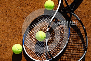 Tennis balls and rackets on clay court, flat lay
