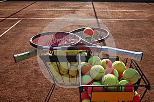 Tennis balls and two tennis rackets