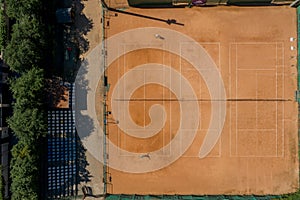 Tennis clay court seen from above with two men playing match. They are mature adult, and very agile and healthy. Video made with