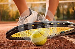 Tennis concept with ball, netting, racket and woman feet