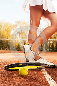 Tennis concept with ball, netting, racket and woman legs
