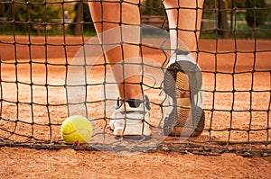 Tennis concept with ball, netting and woman feet