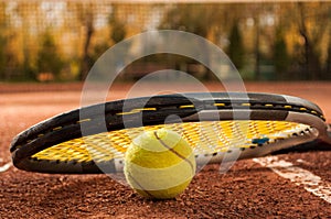 Tennis concept with racket and ball on clay court