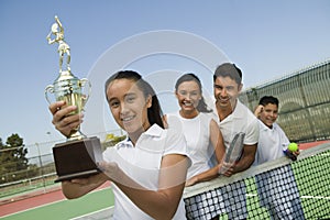 Tennis Family on court by net daughter holding trophy portrait
