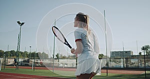 Tennis game on sunny day at tennis court young sportiv woman playing professional tennis.