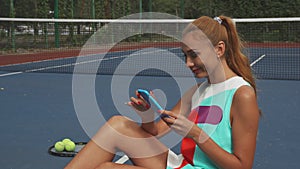 Tennis girl surfing the net while relaxing