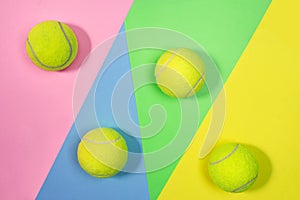 Tennis layout with tennis balls on abstract pastel pink blue yellow green background.