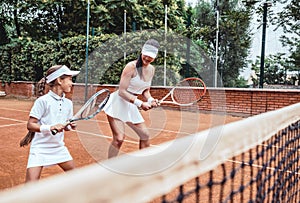 Tennis lesson - instructor working with child photo
