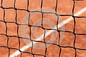 Tennis net. Close-up view of the nodes of a sports net against the background of a court with a ground surface