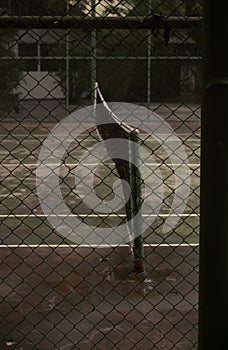 Tennis net in the court behind the fence on the blurry background