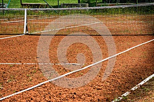 Tennis net at empty red gravel court