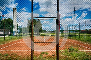 Tennis net at empty red gravel court