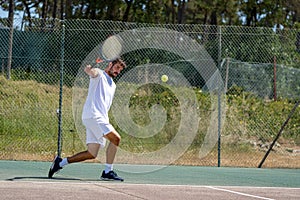 Tennis player hitting backhand at ball