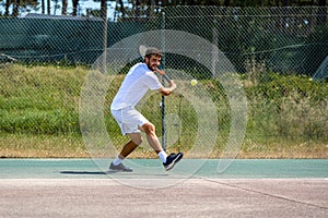 Tennis player hitting backhand at ball