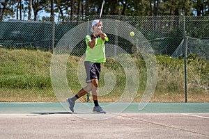 Tennis player hitting backhand at ball