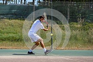 Tennis player hitting backhand at ball