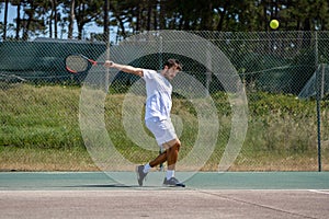 Tennis player hitting backhand at ball