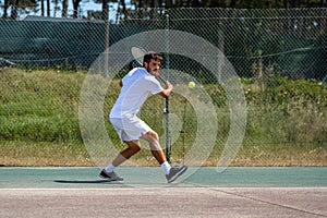 Tennis player hitting backhand at ball