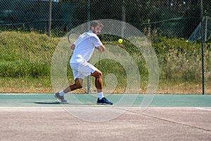 Tennis player hitting backhand at ball