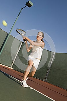 Tennis Player Hitting Backhand on tennis court photo