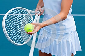 Tennis player holding tennis racket and ball in hand on the tennis court