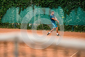 Tennis player improving his skills during an outdoor practice.