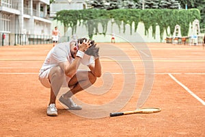 tennis player losing match on court with racket