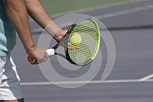 Tennis player with racket and ball on purple hard tennis court prepares to serve. Start of tennis game. copy space
