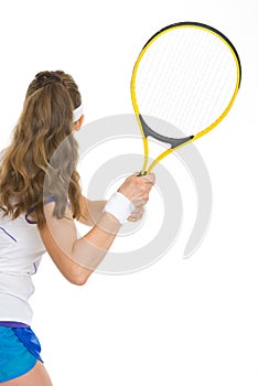 Tennis player ready to hit ball. rear view