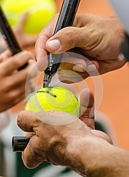 Tennis player signs autograph after win