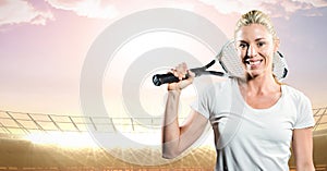 Tennis player smiling against stadium with bright lights and evening sky