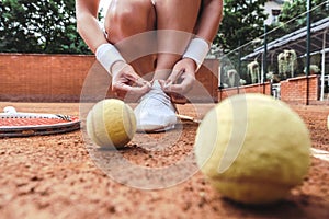 Tennis player tying shoelaces in tennis court