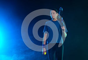 Tennis player woman with racket on tournament. Girl athlete with racket on open court with neon colors. Download a high