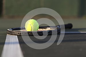 Tennis racket and ball on court.