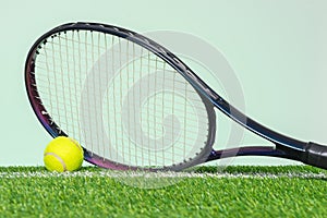 Tennis racket and ball on grass