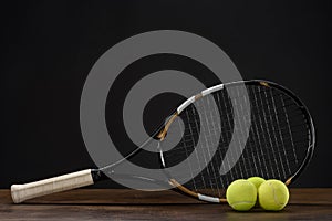 Closeup shot of tennis racket and three balls placed